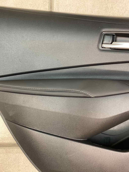 20 21 22 TOYOTA COROLLA MOLDURA DEL PANEL DE LA PUERTA TRASERA IZQUIERDA CUERO NEGRO OEM 6764012R60C3